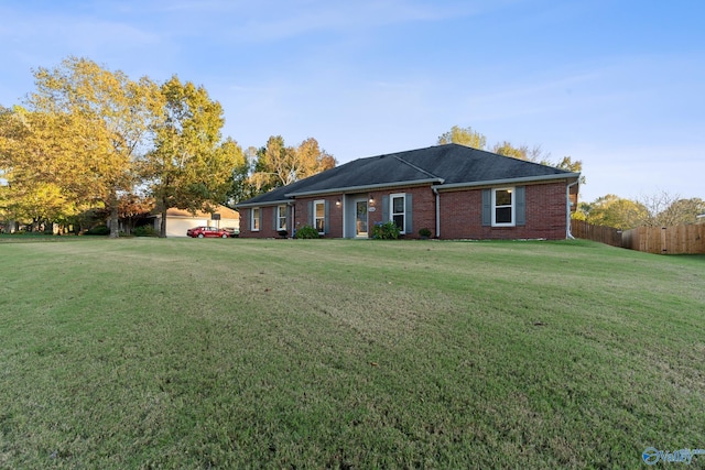 ranch-style home featuring a garage and a front lawn