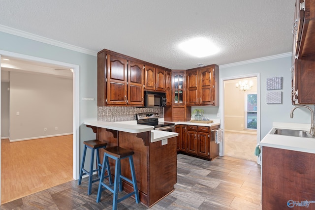 kitchen with stainless steel range with electric stovetop, a breakfast bar, a textured ceiling, sink, and wood-type flooring