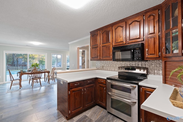 kitchen with kitchen peninsula, decorative backsplash, ornamental molding, a textured ceiling, and electric range