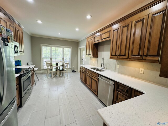 kitchen featuring light stone countertops, sink, backsplash, appliances with stainless steel finishes, and ornamental molding