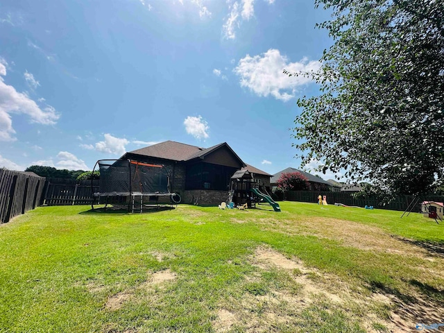 view of yard featuring a playground and a trampoline