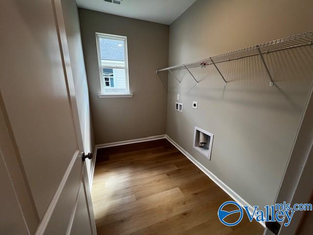 laundry room with hardwood / wood-style flooring, electric dryer hookup, and washer hookup