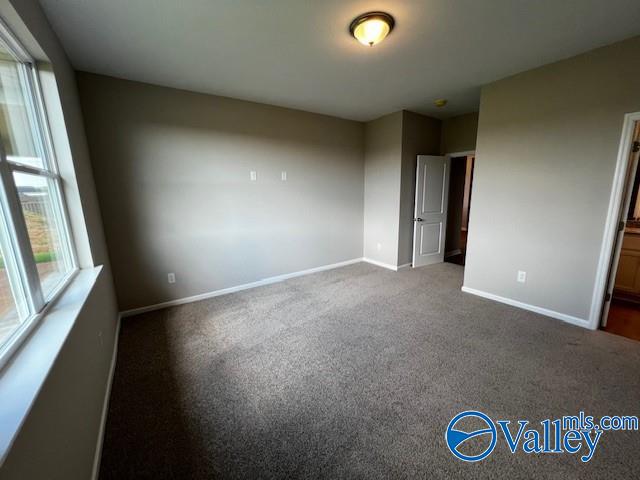 unfurnished bedroom featuring dark carpet