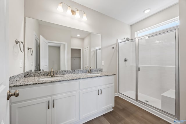 bathroom featuring hardwood / wood-style flooring, vanity, and a shower with shower door