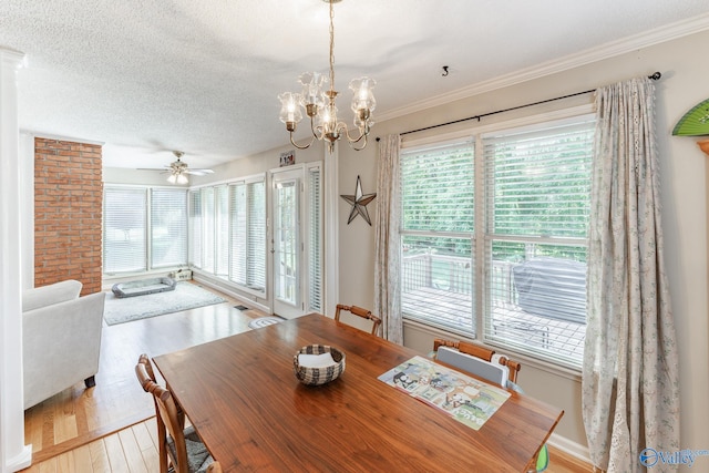 dining area featuring a textured ceiling, crown molding, ceiling fan with notable chandelier, and light wood-type flooring