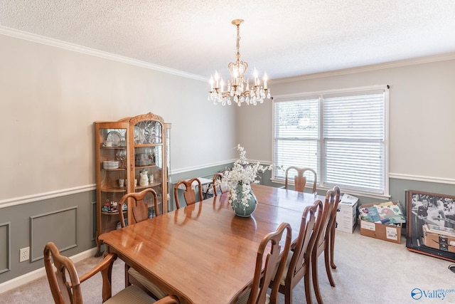 dining room featuring crown molding, light colored carpet, a textured ceiling, and a chandelier