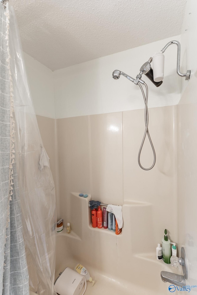 bathroom featuring shower / bathtub combination with curtain and a textured ceiling