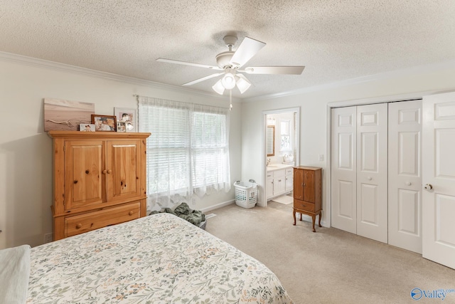 carpeted bedroom featuring a textured ceiling, ensuite bathroom, ceiling fan, and ornamental molding