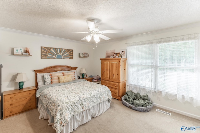 carpeted bedroom with ceiling fan, ornamental molding, and a textured ceiling