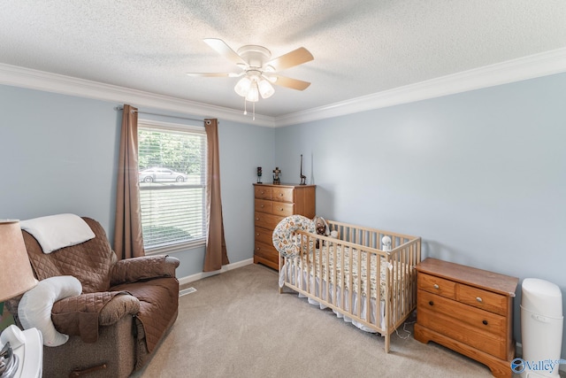 carpeted bedroom featuring ceiling fan, crown molding, and a nursery area