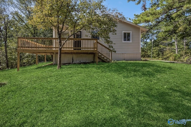 rear view of property with a wooden deck and a yard