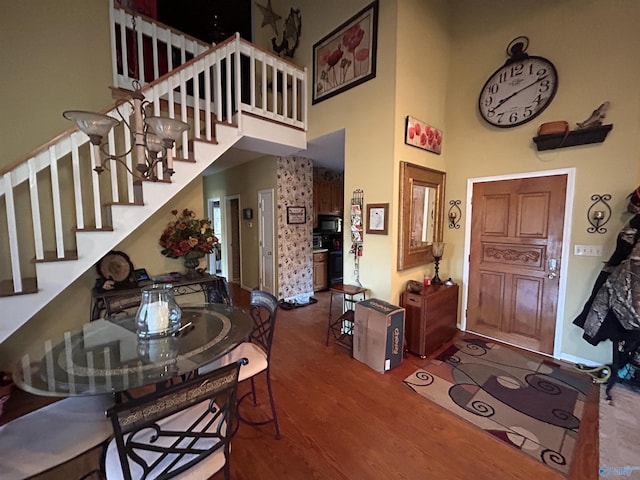 foyer entrance with hardwood / wood-style floors and a high ceiling