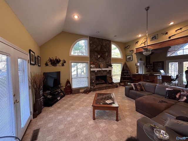 carpeted living room with a fireplace, high vaulted ceiling, and french doors