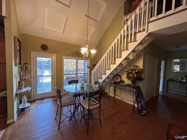 dining area with dark wood-type flooring, high vaulted ceiling, and a notable chandelier