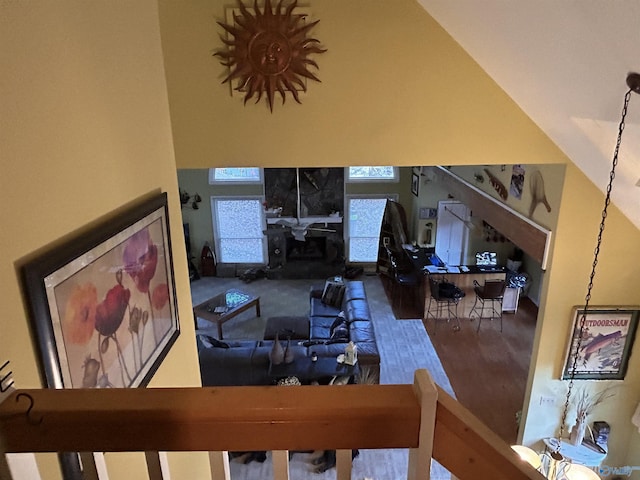 living room with a tiled fireplace and high vaulted ceiling