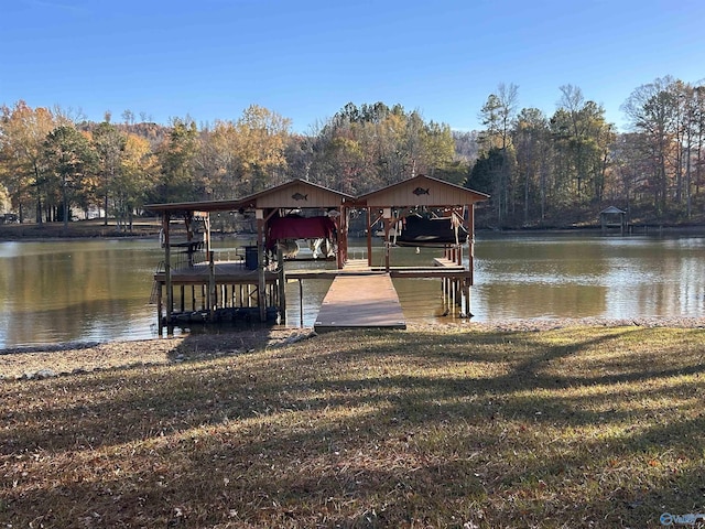 view of dock with a water view and a yard