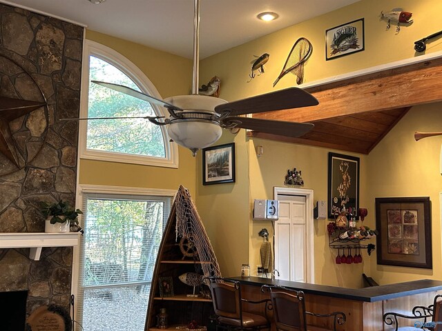 room details featuring ceiling fan and a stone fireplace