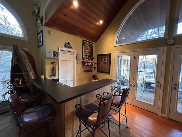 bar with wood ceiling, vaulted ceiling, hardwood / wood-style floors, and french doors