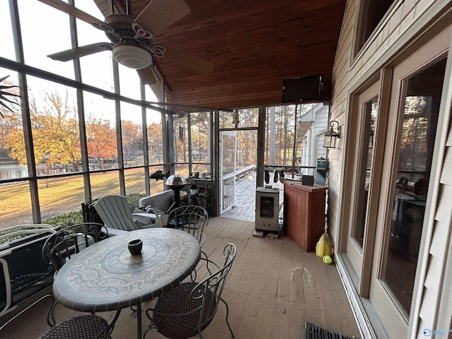 sunroom featuring wood ceiling, ceiling fan, and a wealth of natural light