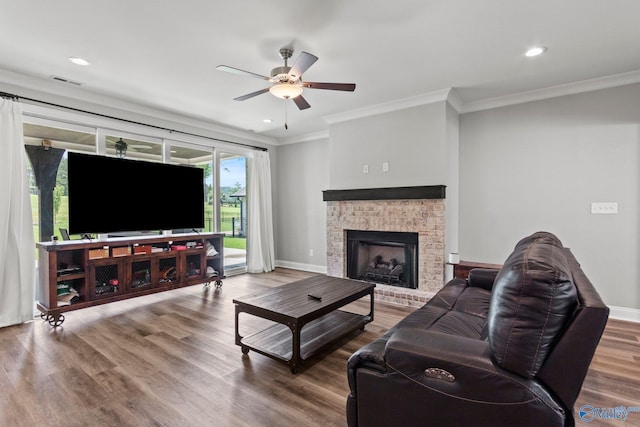 living room featuring ceiling fan, ornamental molding, baseboards, recessed lighting, and wood finished floors