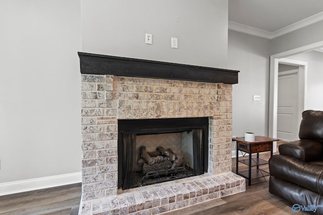 detailed view of wood finished floors, ornamental molding, a brick fireplace, and baseboards