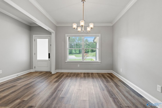 unfurnished dining area with dark wood-style floors, a chandelier, crown molding, and baseboards