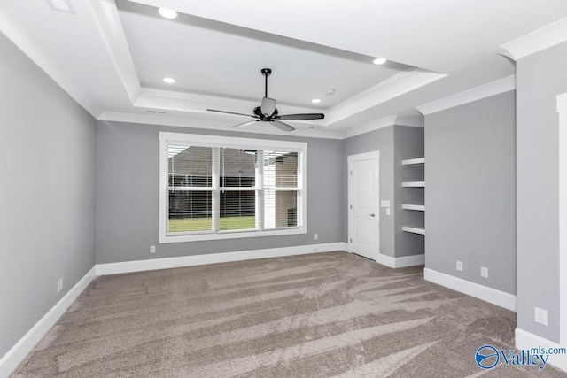 unfurnished bedroom with a raised ceiling, crown molding, carpet flooring, and ceiling fan