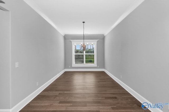 unfurnished dining area with crown molding, dark wood-type flooring, and a notable chandelier