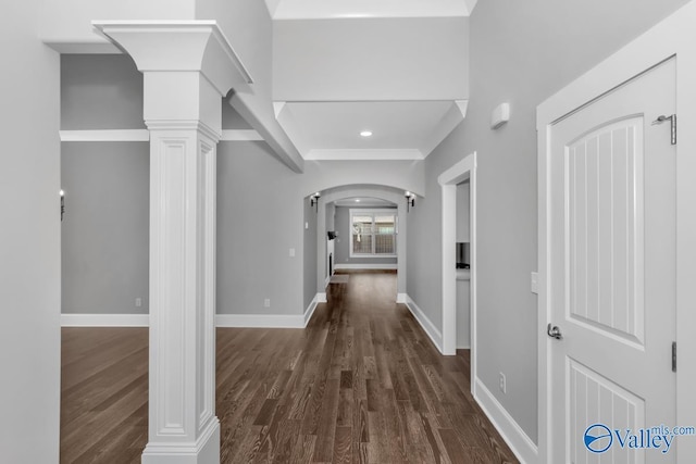 corridor featuring dark hardwood / wood-style floors and ornate columns