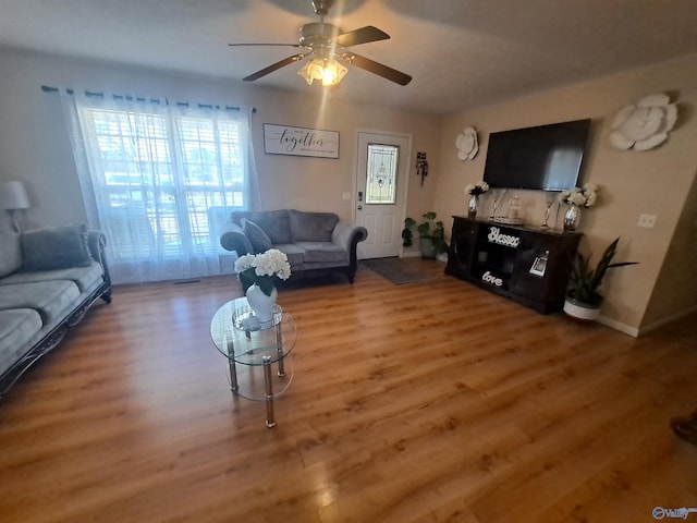 living room featuring wood-type flooring and ceiling fan