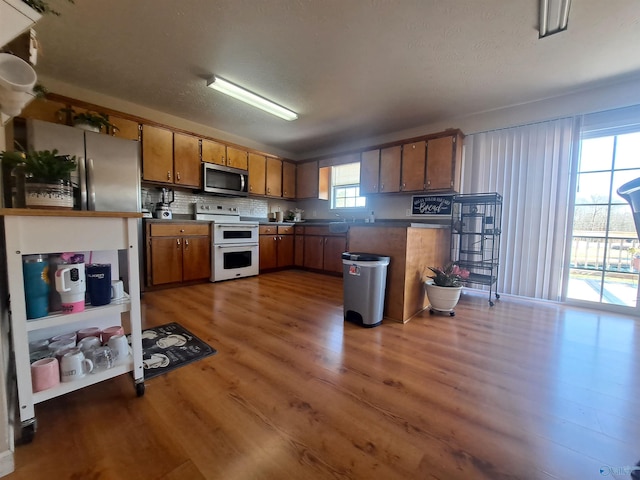 kitchen with double oven range, decorative backsplash, and dark hardwood / wood-style floors