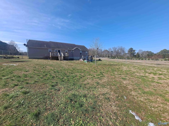 view of yard with a rural view, a playground, and a deck