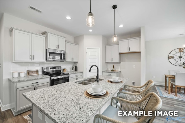 2652 Ajs Arbor Dr NW, Huntsville, AL 35810 - kitchen with an island with sink, backsplash, visible vents, a sink, and appliances with stainless steel finishes
