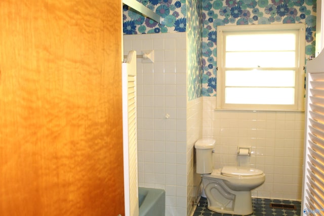 bathroom with tile patterned floors, tile walls, and toilet