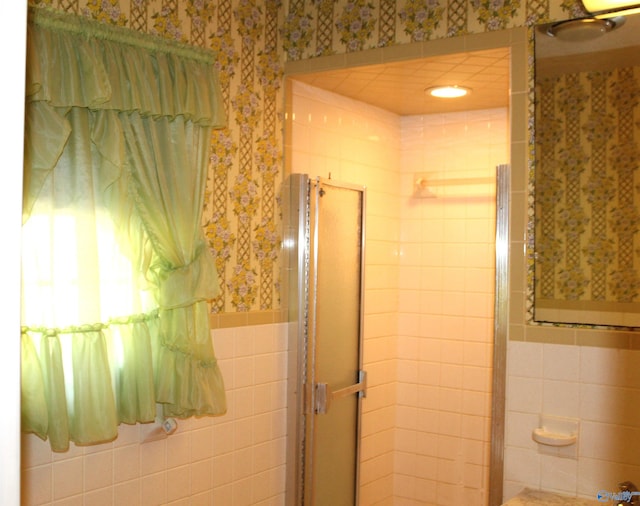 bathroom featuring walk in shower and tile walls