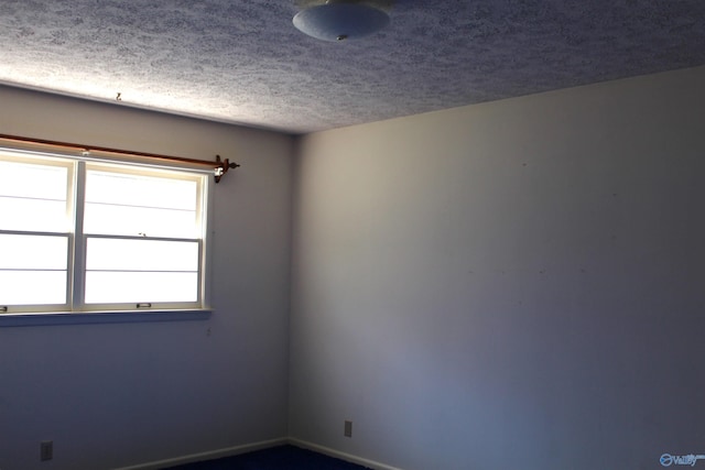 unfurnished room featuring a textured ceiling