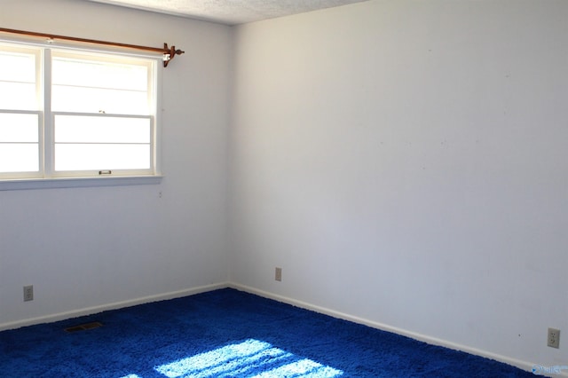 empty room with a textured ceiling and carpet