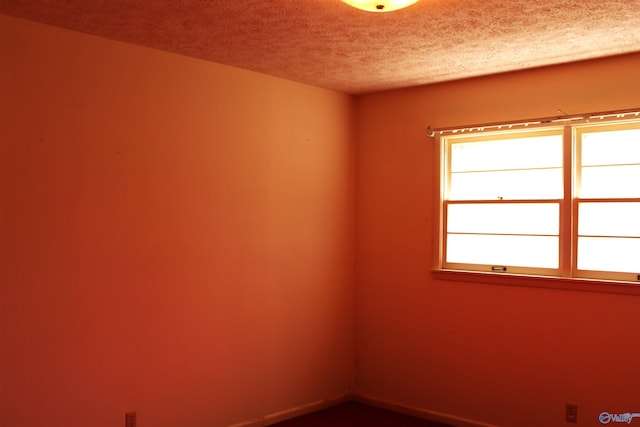 unfurnished room with a textured ceiling