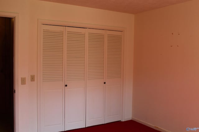 unfurnished bedroom featuring a textured ceiling and a closet