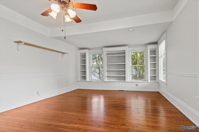 spare room featuring vaulted ceiling with beams, wood-type flooring, and ceiling fan