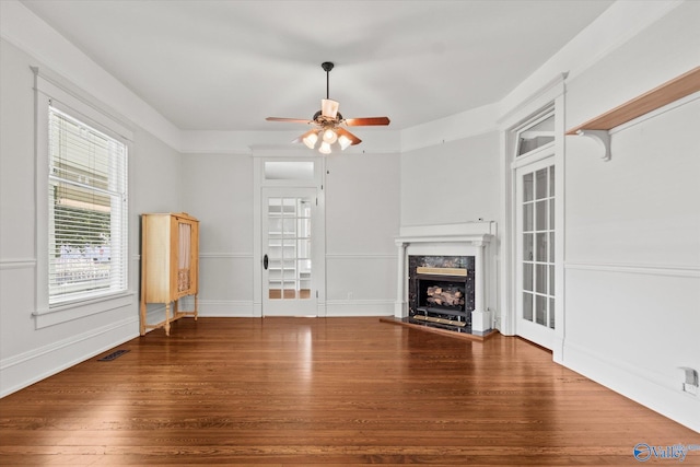 unfurnished living room featuring ceiling fan, hardwood / wood-style flooring, and a fireplace