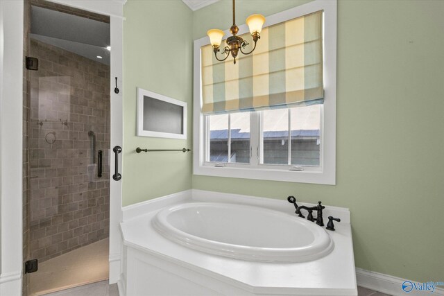 bathroom with shower with separate bathtub and a notable chandelier