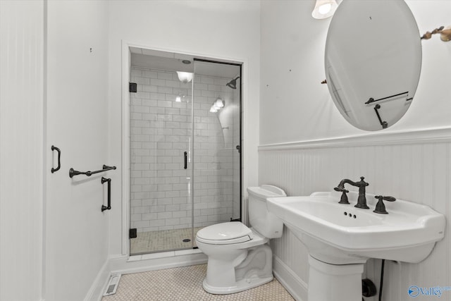 bathroom with tile patterned flooring, toilet, and an enclosed shower