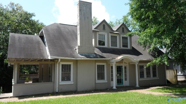 708 E 9th St, Anniston, AL 36207 - back of property featuring a chimney, a yard, stucco siding, and a shingled roof