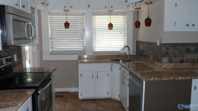 708 E 9th St, Anniston, AL 36207 - kitchen featuring appliances with stainless steel finishes, a sink, decorative backsplash, and tile patterned flooring