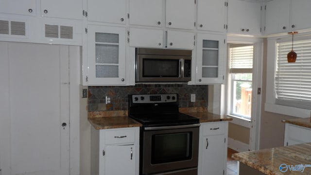 708 E 9th St, Anniston, AL 36207 - kitchen featuring appliances with stainless steel finishes, backsplash, white cabinets, and glass insert cabinets