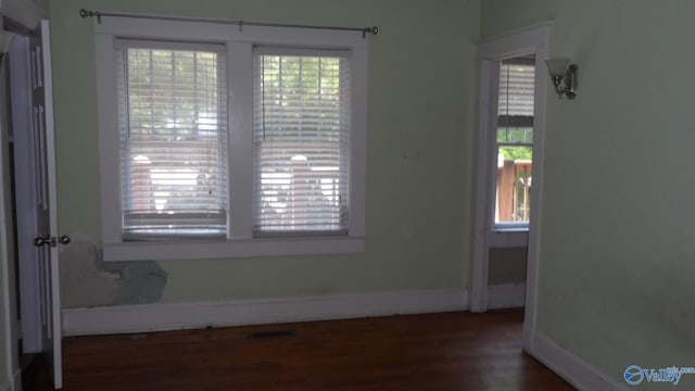 708 E 9th St, Anniston, AL 36207 - empty room featuring plenty of natural light, wood finished floors, and baseboards