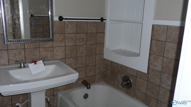 708 E 9th St, Anniston, AL 36207 - bathroom featuring a bath, tile walls, and a sink
