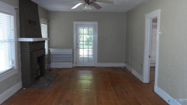 708 E 9th St, Anniston, AL 36207 - unfurnished living room featuring a ceiling fan, a fireplace, wood finished floors, and baseboards