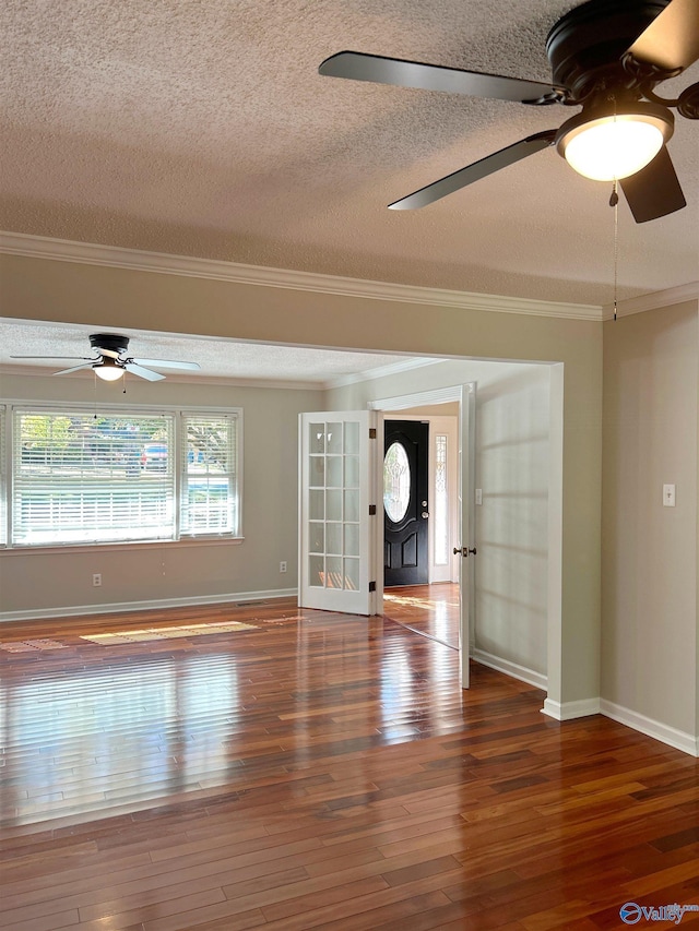 unfurnished living room featuring ornamental molding, dark hardwood / wood-style floors, and a textured ceiling